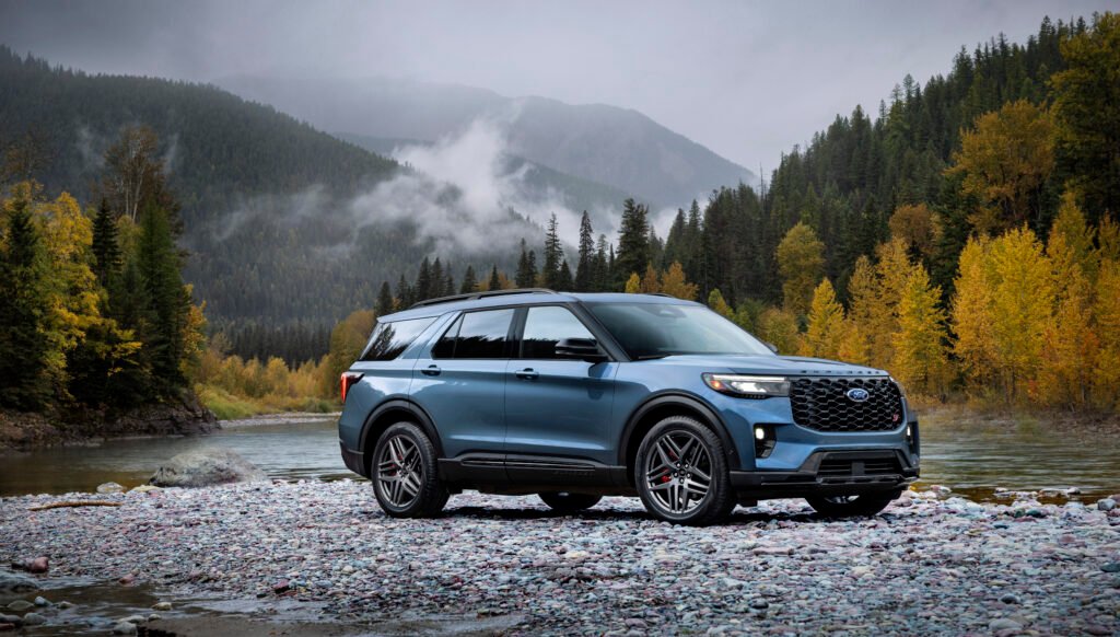 Blue Ford Explorer parked beside a mountain river in Canada