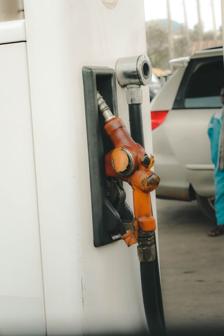 Orange fuel nozzle at a filling station, real stock photograph